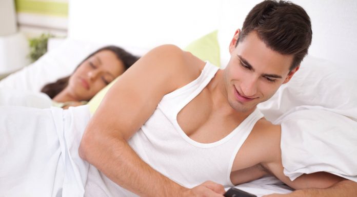 Afinal, por que os homens traem? Homem mexendo celular mulher dormindo